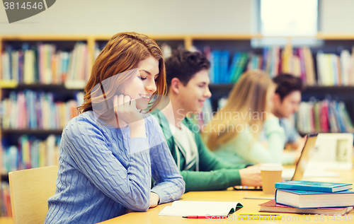 Image of happy student girl reading books in library