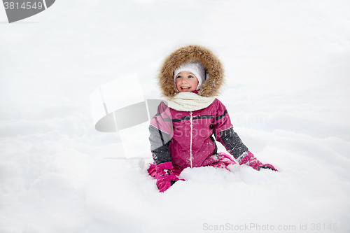 Image of happy little kid or girl in winter clothes on snow