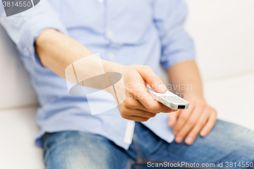 Image of close up of man with tv remote control at home