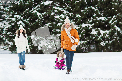 Image of happy family with sled walking in winter forest