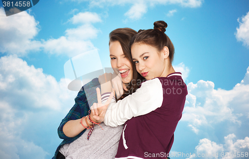 Image of happy teenage girls hugging and showing peace sign