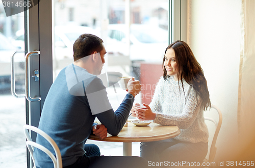 Image of happy couple drinking tea and coffee at cafe