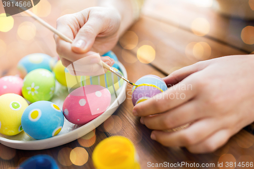 Image of close up of woman hands coloring easter eggs