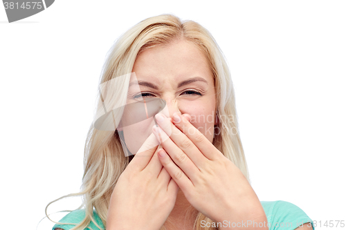 Image of young woman or teenage girl closing her nose