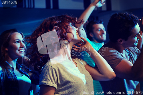 Image of happy friends dancing at night club