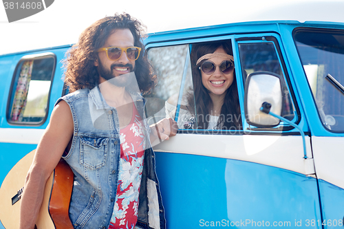 Image of smiling young hippie friends over minivan car