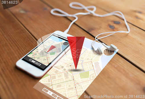 Image of close up of smartphone and earphones on wood