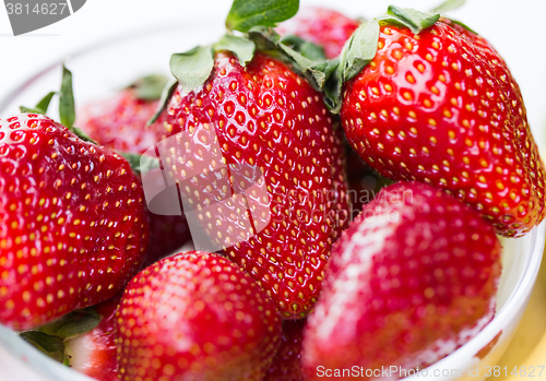 Image of close up of ripe red strawberries over white