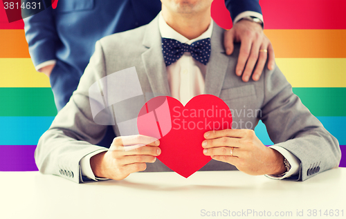 Image of close up of male gay couple with red heart