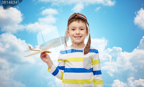 Image of happy little boy in aviator hat with airplane
