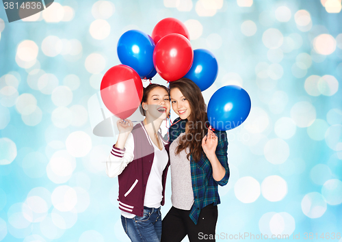 Image of happy teenage girls with helium balloons