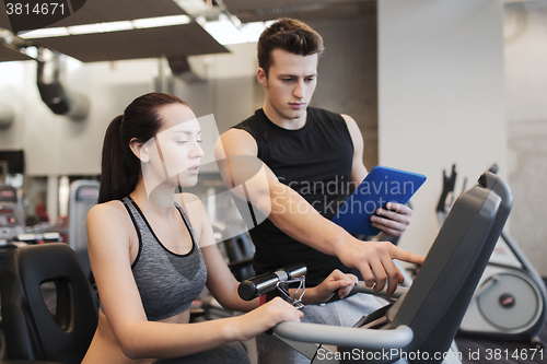 Image of woman with trainer on exercise bike in gym