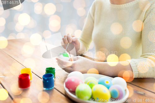 Image of close up of woman hands coloring easter eggs