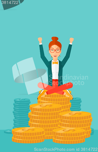 Image of  Happy business woman sitting on coins.