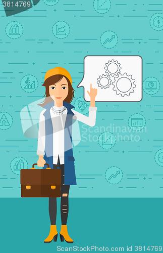 Image of Business woman pointing at cogwheels.