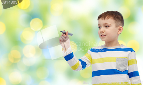 Image of little boy drawing or writing with marker