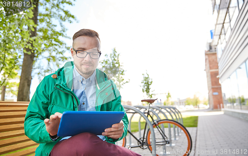 Image of happy young hipster man with tablet pc and bike