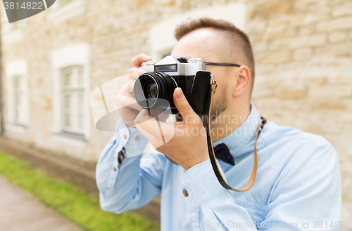 Image of close up of hipster man with film camera in city