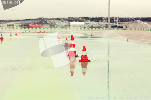 Image of traffic cones and sprinklers on wet speedway