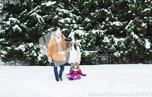 Image of happy family with sled walking in winter forest