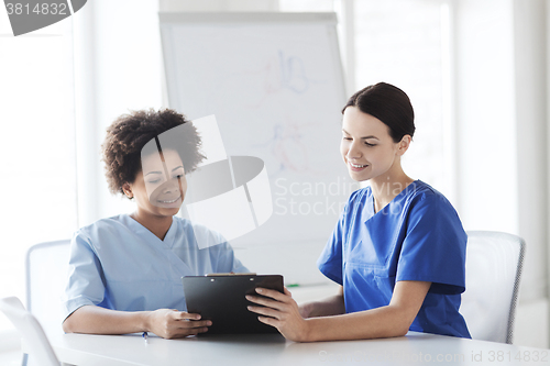 Image of happy doctors with tablet pc meeting at hospital