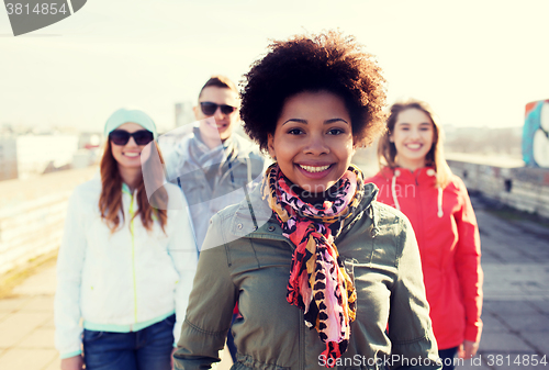 Image of group of happy teenage friends on city street