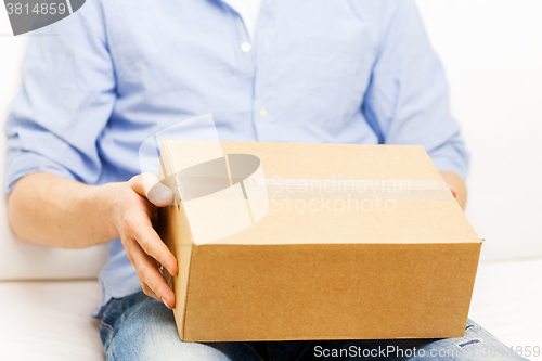 Image of close up of man with cardboard box parcel at home