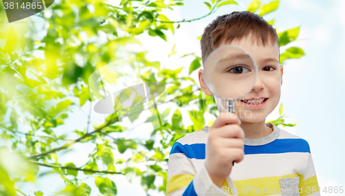 Image of happy little boy looking through magnifying glass