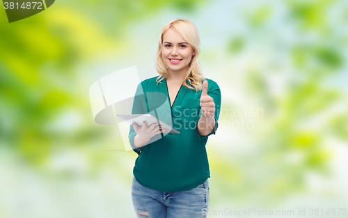 Image of smiling woman with tablet pc showing thumbs up