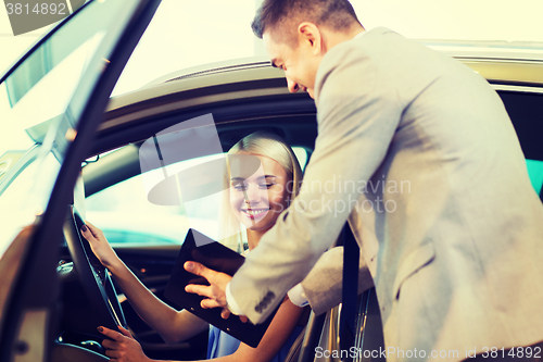 Image of happy woman with car dealer in auto show or salon