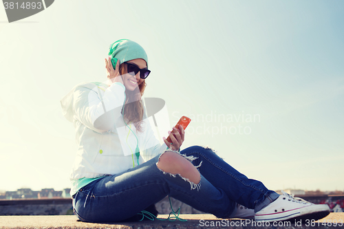 Image of happy young woman with smartphone and headphones