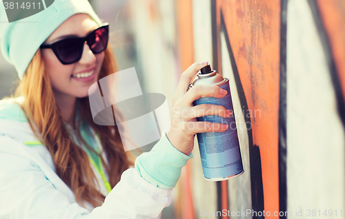 Image of close up of woman with spray paint making graffiti