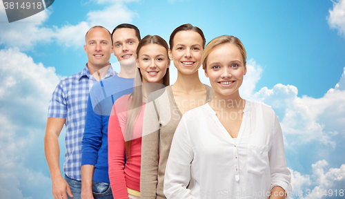 Image of group of smiling people over blue sky and clouds