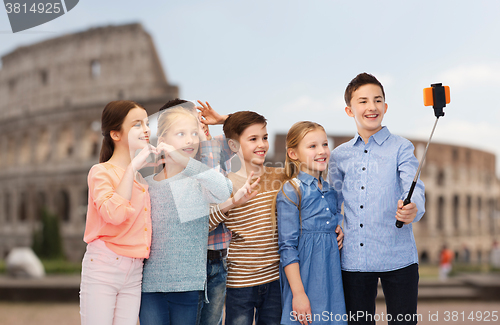 Image of kids with smartphone selfie stick over coliseum