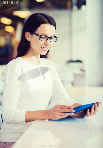 Image of smiling woman with tablet pc at cafe