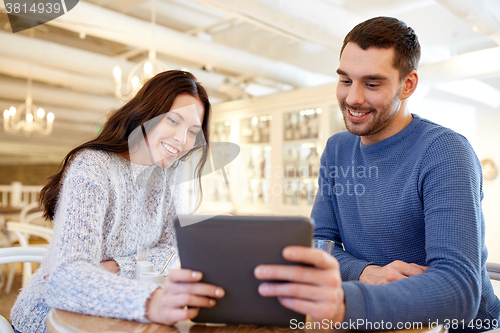 Image of happy couple with tablet pc drinking tea at cafe