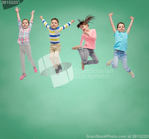Image of happy little girl jumping in air over school board
