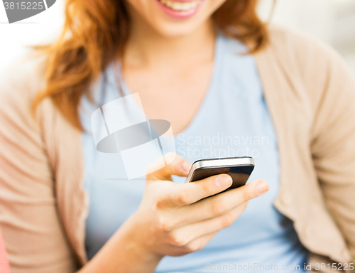 Image of close up of woman texting on smartphone at home