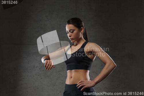 Image of young woman with heart-rate watch in gym