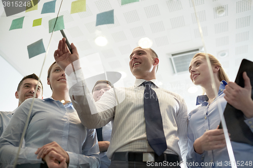 Image of smiling business people with marker and stickers