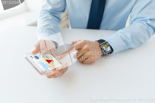 Image of close up of hands with smart phone and watch