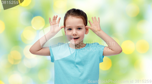 Image of happy little girl having fun and making ears