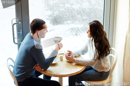 Image of happy couple drinking tea and coffee at cafe