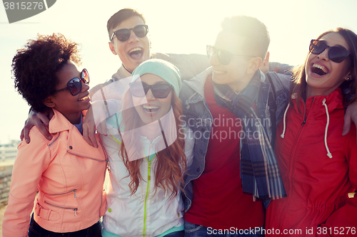 Image of smiling friends in sunglasses laughing on street