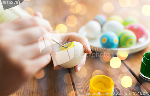 Image of close up of woman hands coloring easter eggs