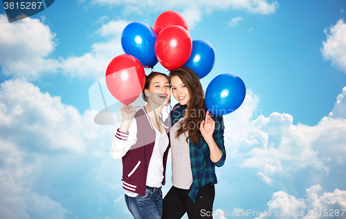 Image of happy teenage girls with helium balloons over sky