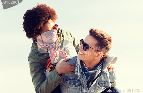 Image of happy teenage couple in shades having fun outdoors