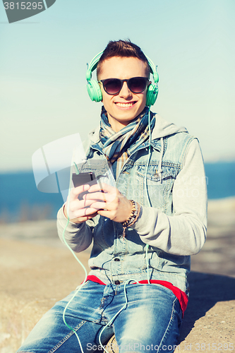 Image of happy young man in headphones with smartphone