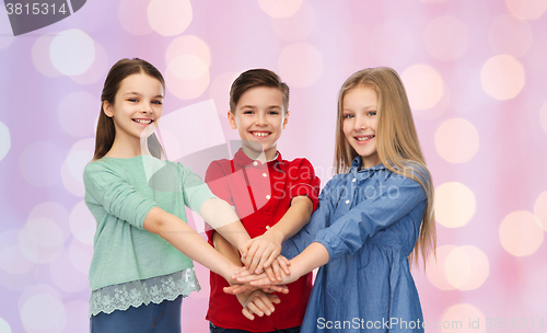 Image of happy children with hands on top