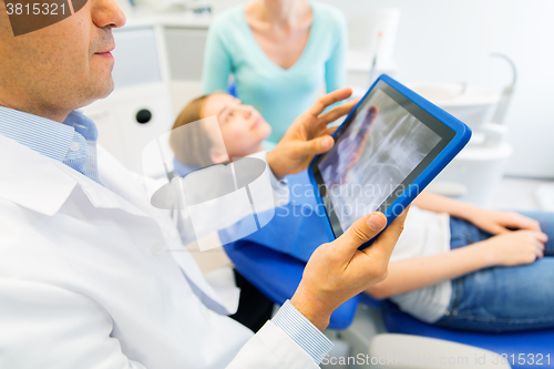 Image of dentist with x-ray on tablet pc with patient girl